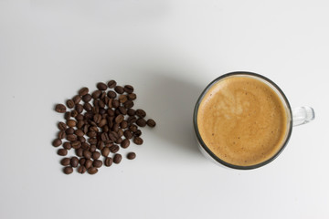 cup of coffee on white table and coffee beans