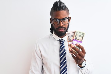 African american businessman with braids holding dollars over isolated white background with a confident expression on smart face thinking serious