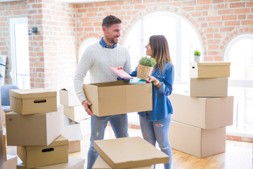 Young beautiful couple moving cardboard boxes at new home