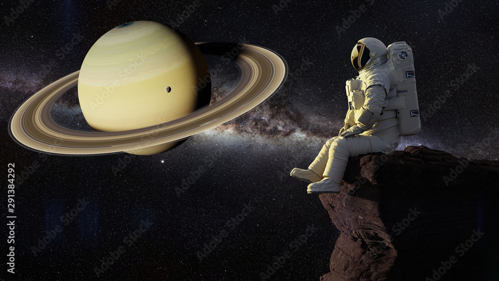 Wall mural astronaut sitting on a cliff on one of the moons of saturn