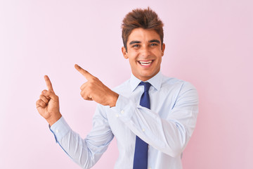 Young handsome businessman wearing shirt and tie standing over isolated pink background smiling and looking at the camera pointing with two hands and fingers to the side.