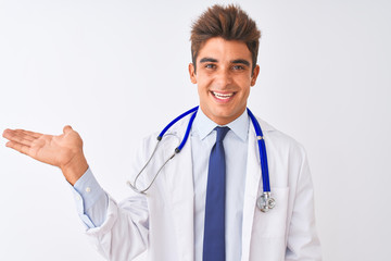 Young handsome doctor man wearing stethoscope over isolated white background smiling cheerful presenting and pointing with palm of hand looking at the camera.