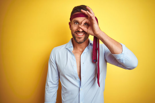 Hangover business man drunk and crazy for hangover wearing tie on head doing ok gesture with hand smiling, eye looking through fingers with happy face.