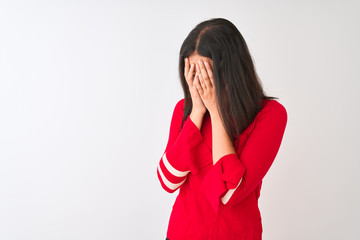 Young beautiful chinese woman wearing red dress standing over isolated white background with sad expression covering face with hands while crying. Depression concept.