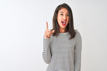 Young beautiful chinese woman wearing striped t-shirt standing over isolated white background pointing finger up with successful idea. Exited and happy. Number one.