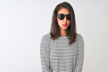 Chinese woman wearing striped t-shirt and sunglasses standing over isolated white background depressed and worry for distress, crying angry and afraid. Sad expression.
