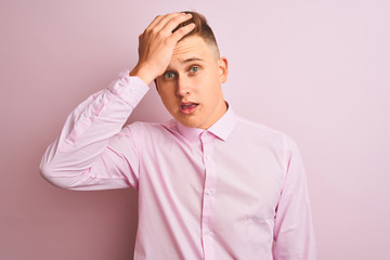 Young handsome businessman wearing elegant shirt standing over isolated pink background surprised...