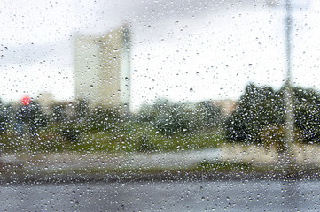raindrops on glass, dank damp weather outside the window on a busy highway