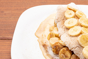 Tapioca filled with banana, cinnamon and condensed milk, on wooden background. Flatbread made from cassava (also known as casabe, bammy, beiju, bob, biju).