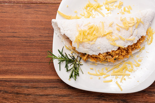 Tapioca filled with chiken breast and cheese on wooden background. Flatbread made from cassava (also known as casabe, bammy, beiju, bob, biju).