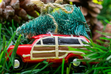Christmas Tree on a toy car on bright yellow background. Winter Holidays celebration concept.