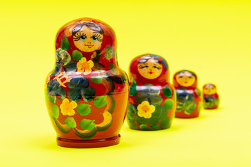 Colorful Nesting wooden Dolls isolated on bright yellow background. National Russian souvenirs. Babushkas or Matryoshkas.