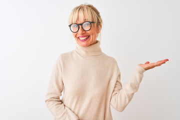 Middle age woman wearing turtleneck sweater and glasses over isolated white background smiling cheerful presenting and pointing with palm of hand looking at the camera.