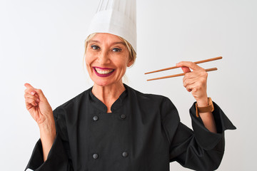 Middle age chef woman wearing cap holding chopsticks over isolated white background very happy pointing with hand and finger to the side