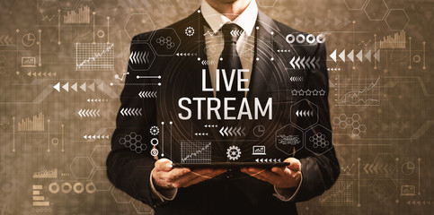 Live stream with businessman holding a tablet computer on a dark vintage background