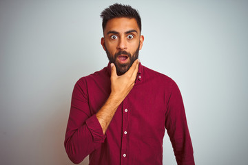 Young indian man wearing red elegant shirt standing over isolated grey background Looking...