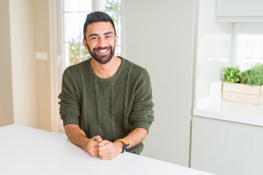 Handsome hispanic man wearing casual sweater at home with a happy and cool smile on face. Lucky person.