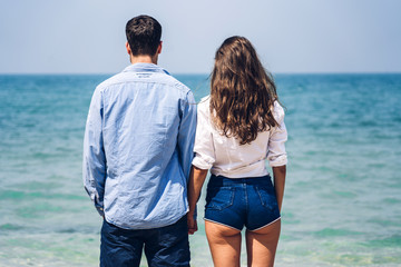Romantic lovers young couple relaxing together on the tropical beach.Man holding hand with woman and enjoy life.Summer vacations