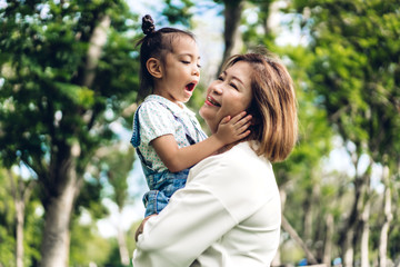 Portrait of happy grandmother and little cute girl enjoy relax together in summer park.Family and togetherness