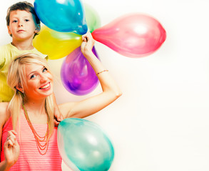 pretty real family with color balloons on white background, blond woman with little boy at birthday party bright smiling mother