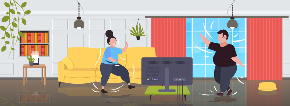 fat obese couple exercising during tv show overweight man woman training while watching fitness program home workout weight loss concept modern living room interior full length horizontal