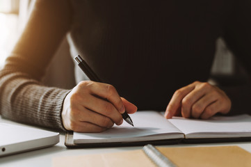 businessman hand working with new modern computer and writing on the notepad strategy diagram as concept morning light