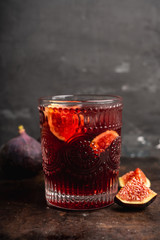 Old-fashioned cocktail with figs on the rustic background. Selective focus. Shallow depth of field.