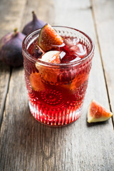 Old-fashioned cocktail with figs on the rustic background. Selective focus. Shallow depth of field.