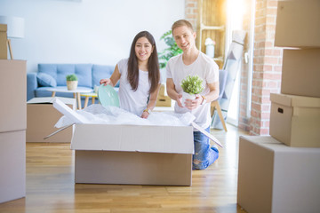 Young beautiful couple open cardboard boxes to order new home