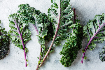 Freshly cut purple Kale leaves on a light textured background.