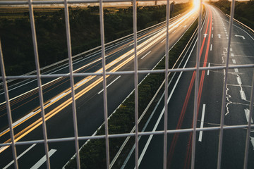 Photographing the highway after sunset through a wire fence