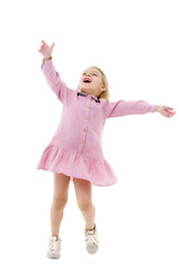 A little girl in a dress is spinning.