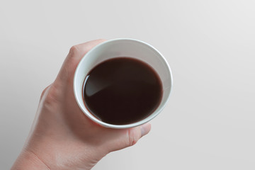 Close-up of a person drinking coffee in a paper cup.  紙コップでコーヒーを飲む人のクローズアップ