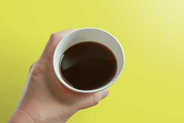 Close-up of a person drinking coffee in a paper cup.  紙コップでコーヒーを飲む人のクローズアップ