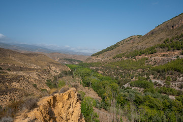 Panoramic view of the Lucainena River with its green leafy trees.
