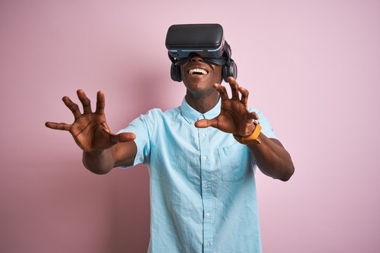 Young african american man playing virtual reality game using goggles