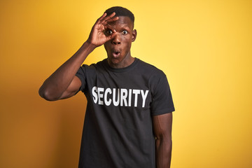African american safeguard man wearing security uniform over isolated yellow background doing ok...