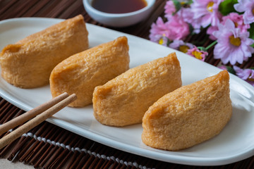 Fototapeta na wymiar Rice ball wrapped in deep fried tofu pouches (Inari Sushi), Japanese food.