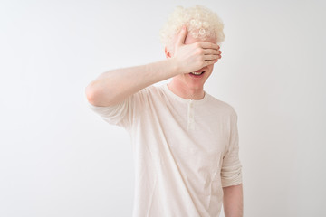 Young albino blond man wearing casual t-shirt standing over isolated white background smiling and...