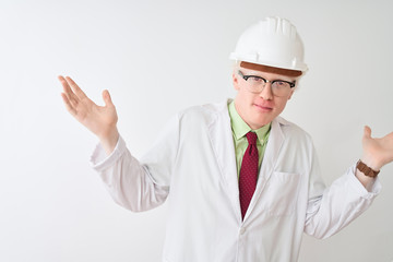 Albino scientist man wearing glasses and helmet standing over isolated white background clueless and confused expression with arms and hands raised. Doubt concept.