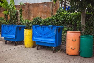 Small and large plastic bins recycle on the street