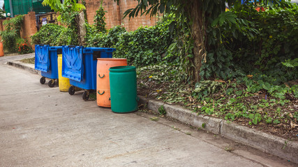 Small and large plastic bins recycle on the street
