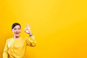 Happy woman showing OK gesture isolated on background