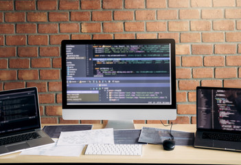 Computer of the software developer on the desk in the room office.