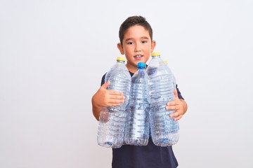 Beautiful kid boy recycling plastic bottles standing over isolated white background with a happy face standing and smiling with a confident smile showing teeth