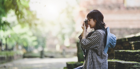 Fototapeta premium Young asian traveler taking the photo of the old temple