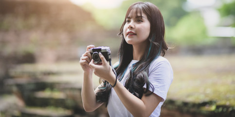 Adorable asian traveler taking the photo of the old temple