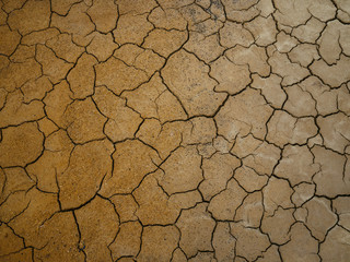 Drought in brown soil. Many cracks from lack of moisture