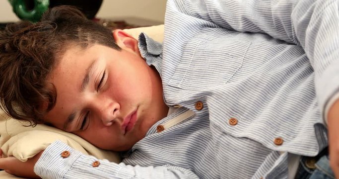 Portrait of a fast asleep young boy lying on sofa