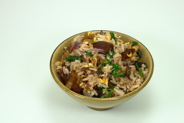 Chinese traditional fried rice with pork and fresh vegetable on the yellow bowl.